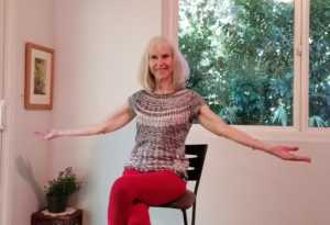 Patricia Becker showing arm stretches for online Chair yoga
