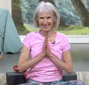 Patricia Becker sits in the lotus position leading an Aging with Grace yoga series for seniors new to yoga and need to increase flexibility